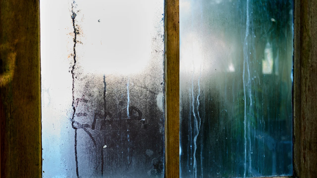 Condensation droplets on window glass with mould on frame