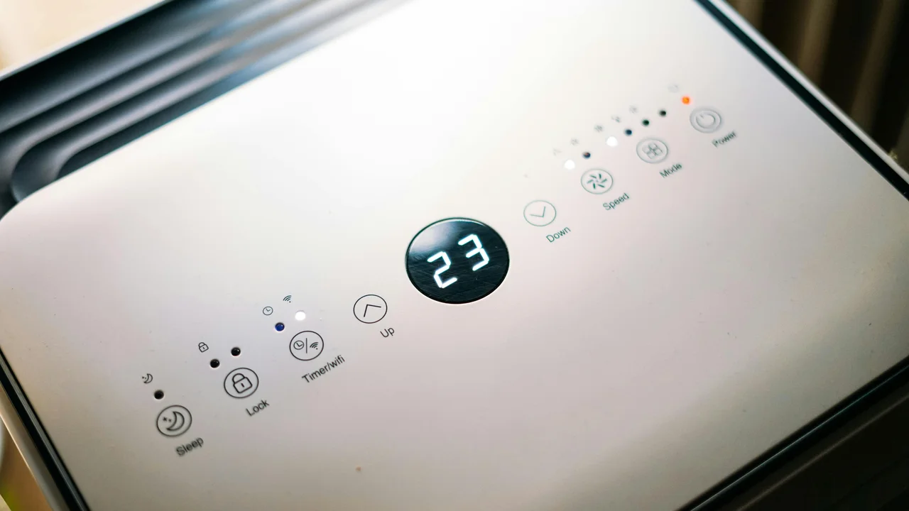 Dehumidifier running in modern UK home interior, humidity control device