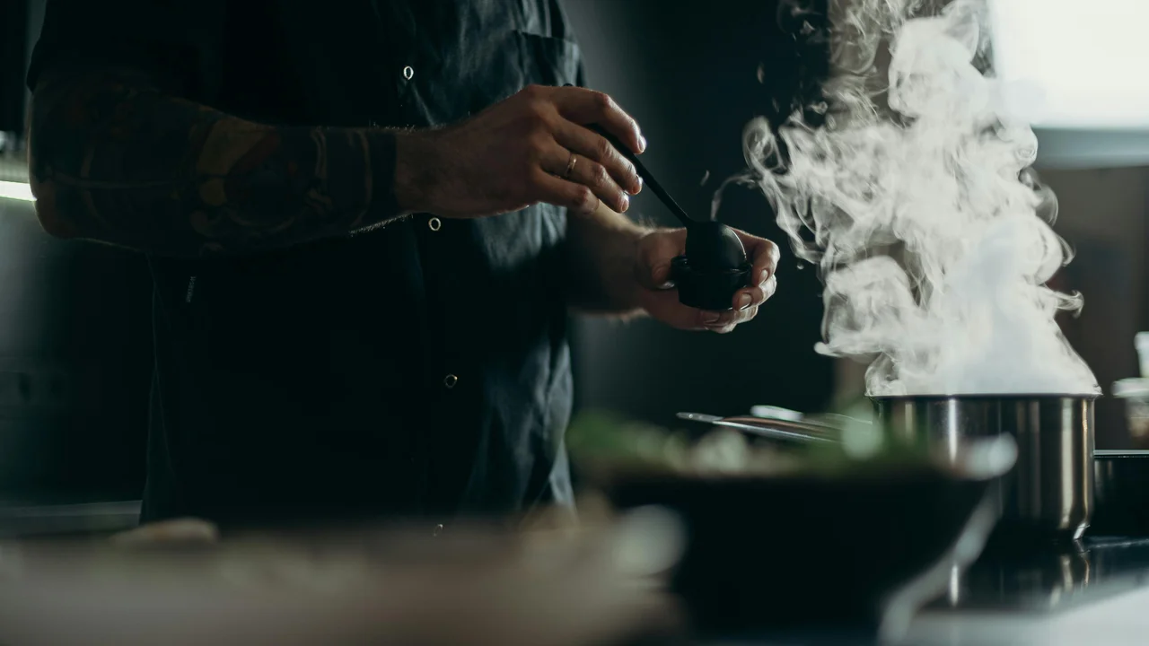 Person cooking with steam rising in UK kitchen, lifestyle moisture